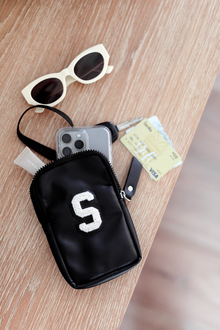 Black zippered phone pouch with embroidered letter S, perfect for keys and cards, stylish and practical.