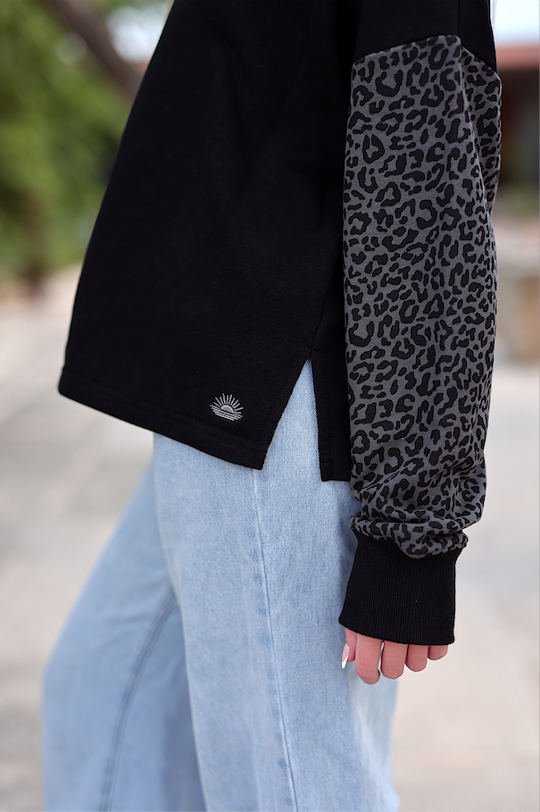 Black long sleeve t-shirt with leopard print sleeves made of soft cotton, perfect for casual wear.