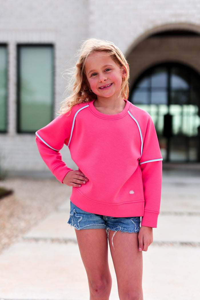 Cute pink kids' sweatshirt made of soft material, featuring raglan sleeves and stylish accent details.