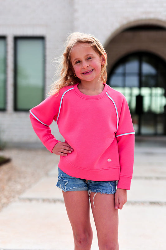 Cute pink kids' sweatshirt made of soft material, featuring raglan sleeves and stylish accent details.