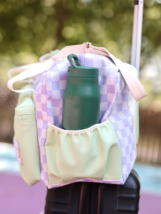 Colorful checkerboard backpack with mint green accents and a water bottle holder.