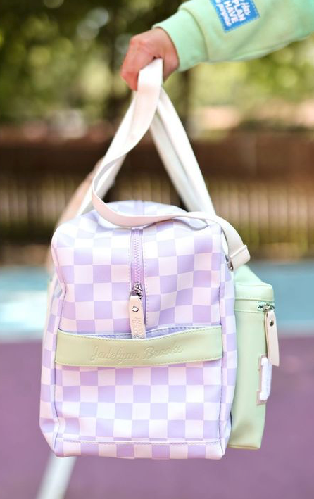 Purple and green checkered tote bag with zip closure and side pocket, perfect for stylish everyday use.
