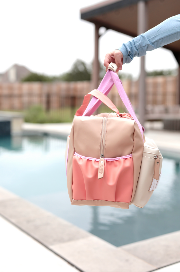 Stylish peach and beige tote bag with pink straps, perfect for beach or pool outings.