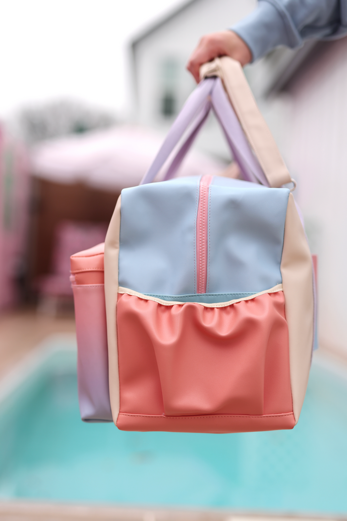 Colorful multifunctional bag in pastel pink, blue, and cream, made of durable material, perfect for outings.
