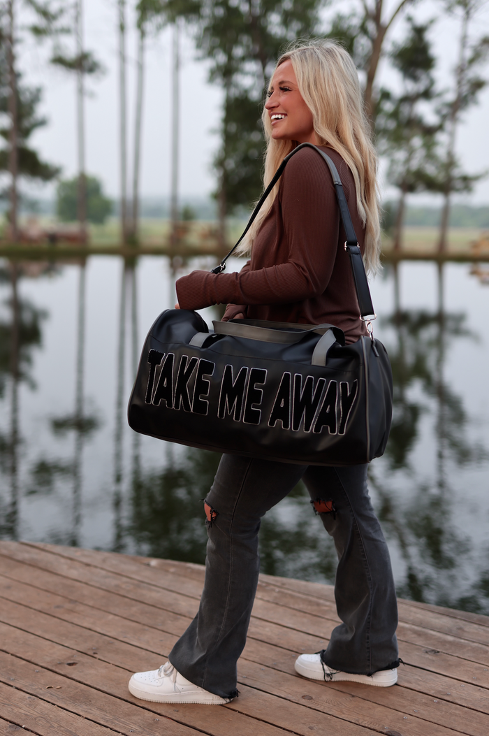 Stylish black duffel bag with 'TAKE ME AWAY' text, perfect for travel or gym use.