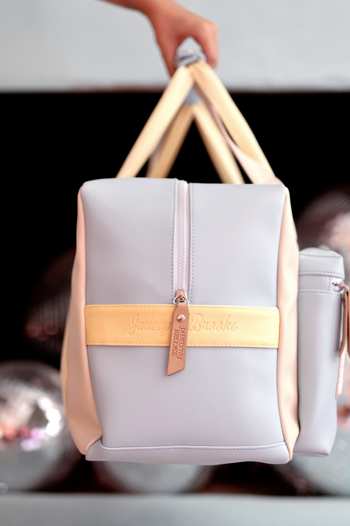 Stylish grey tote bag with yellow accent and zipper, made from durable material, perfect for everyday use.