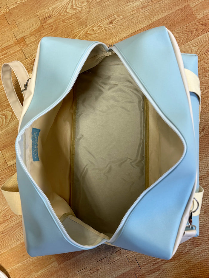 Light blue travel bag with a spacious interior and zipper closure, perfect for weekend getaways.