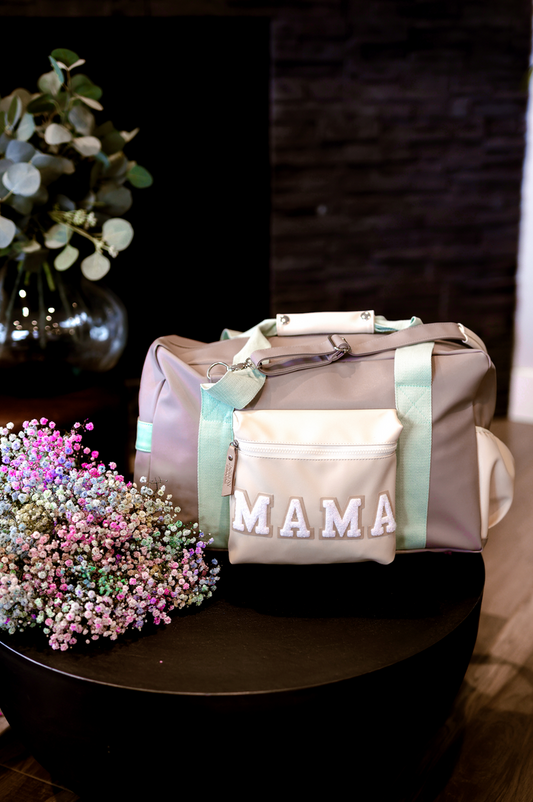 Stylish beige and mint duffel bag with 'MAMA' embroidery and zippered pocket, perfect for moms on the go.