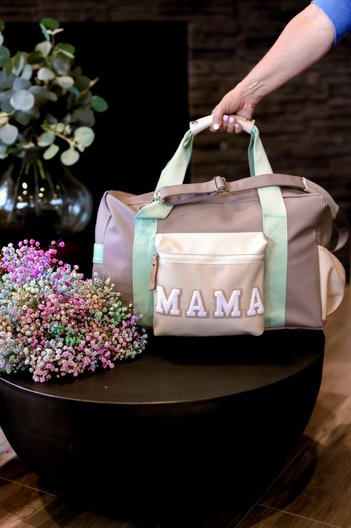 Stylish grey duffel bag with mint green straps and 'MAMA' embroidery, perfect for moms on the go.