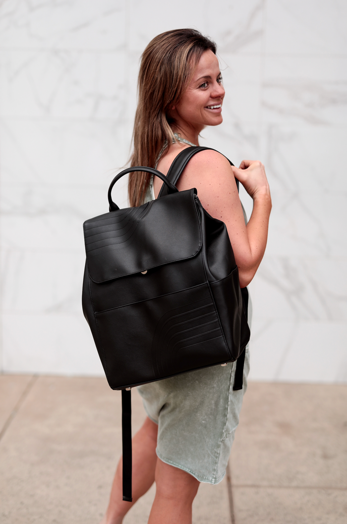 Stylish black leather backpack with front pocket, perfect for both casual and formal use.