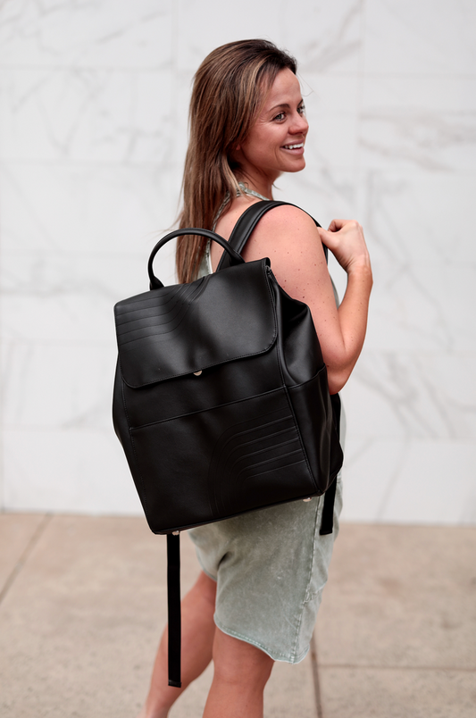 Stylish black leather backpack with front pocket, perfect for both casual and formal use.