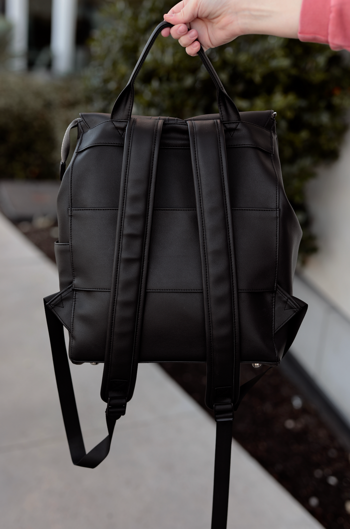 Black vegan leather backpack with dual handles and adjustable straps, perfect for casual outings.