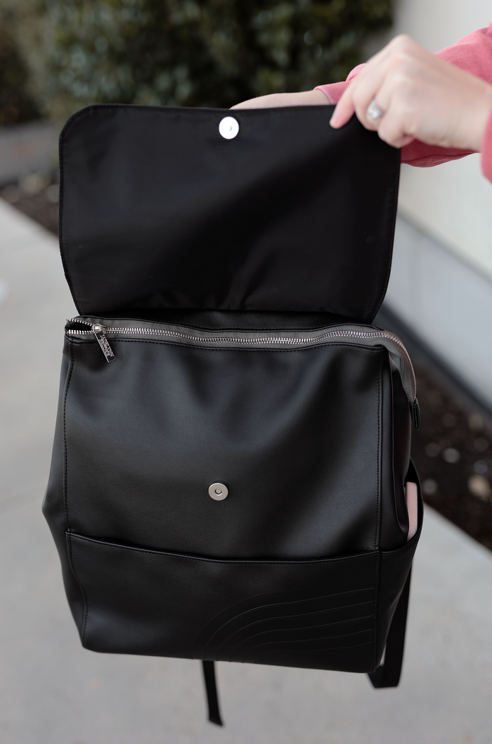 Black vegan leather backpack with zipper closure and front pocket, ideal for everyday use.