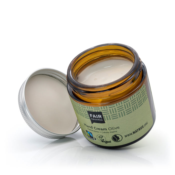 Glass Jar of Fair Squared Olive Oil hand cream with a green label on a white background