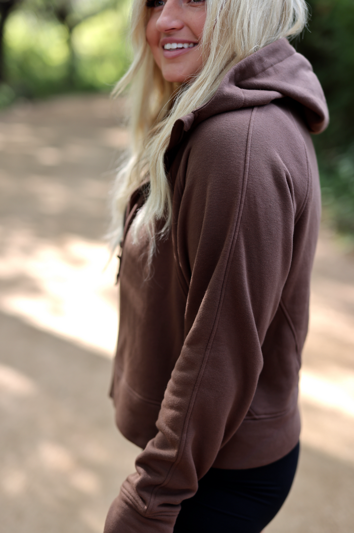 Brown hoodie made of soft material, featuring a relaxed fit and a cozy hood for comfort.