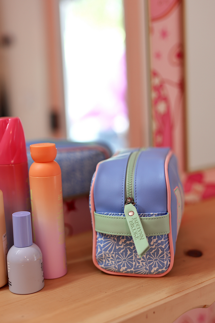 Multi-color cosmetic bag made of durable material with floral design, ideal for makeup and toiletries.