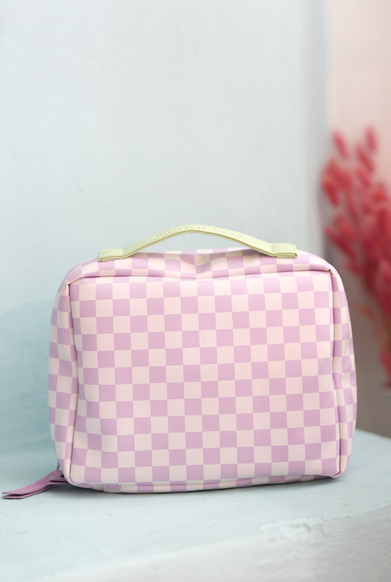 Pink checkered cosmetic bag with a yellow handle, stylish and spacious for makeup essentials.
