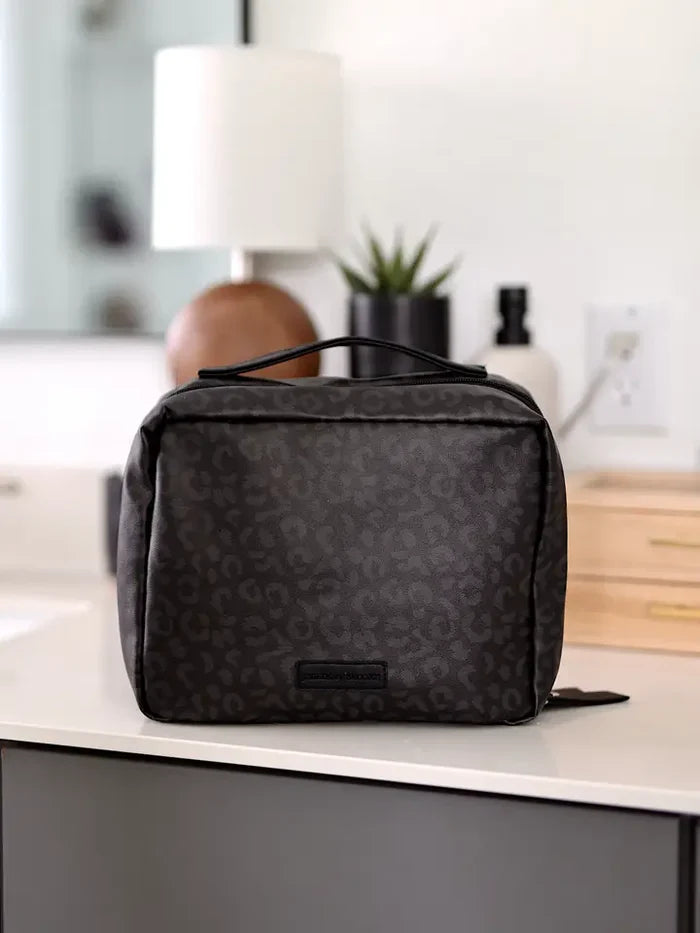 Black leopard print cosmetic bag with handle, perfect for travel and organization.