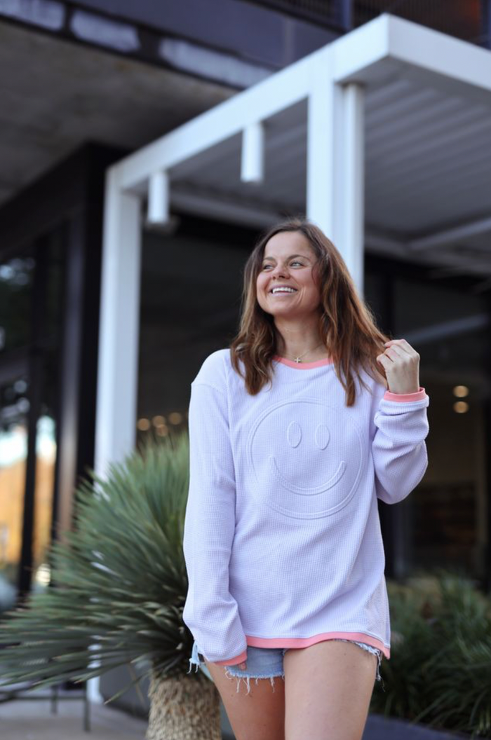 Women’s light purple smiley face sweatshirt, soft fabric, stylish with pink trim, perfect for casual wear.