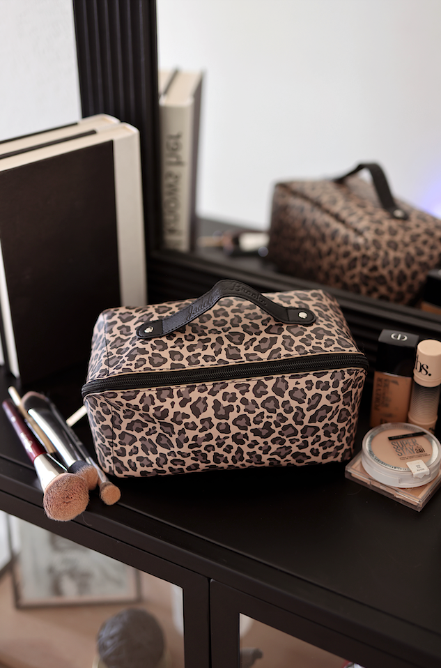Leopard print cosmetic bag with zipper and handle, perfect for makeup storage and travel.