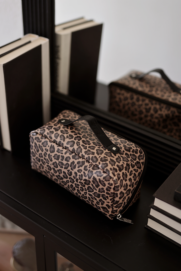 Leopard print cosmetic bag with a zipper and handle, perfect for makeup organization.
