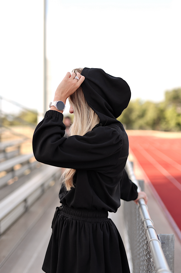Black hooded sweatshirt with elastic waist, perfect for casual wear or workouts.