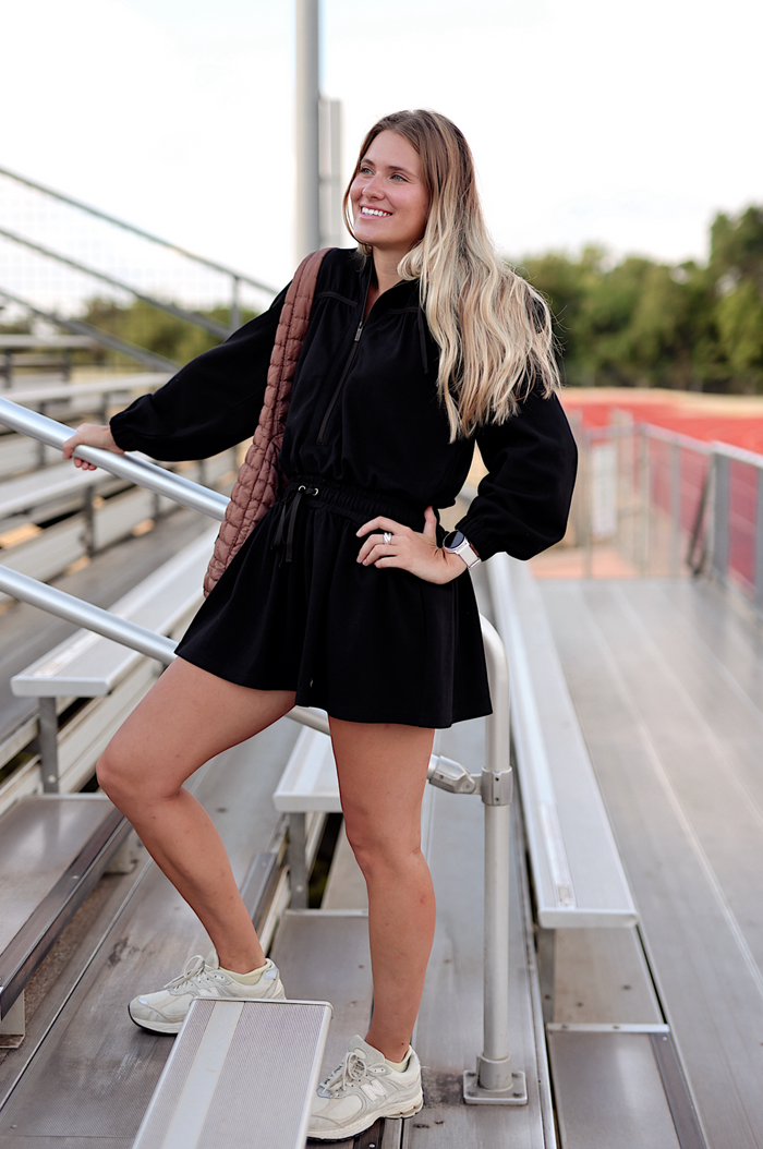 Black women's zip-up romper with elastic waist, perfect for casual outings and sporty looks.