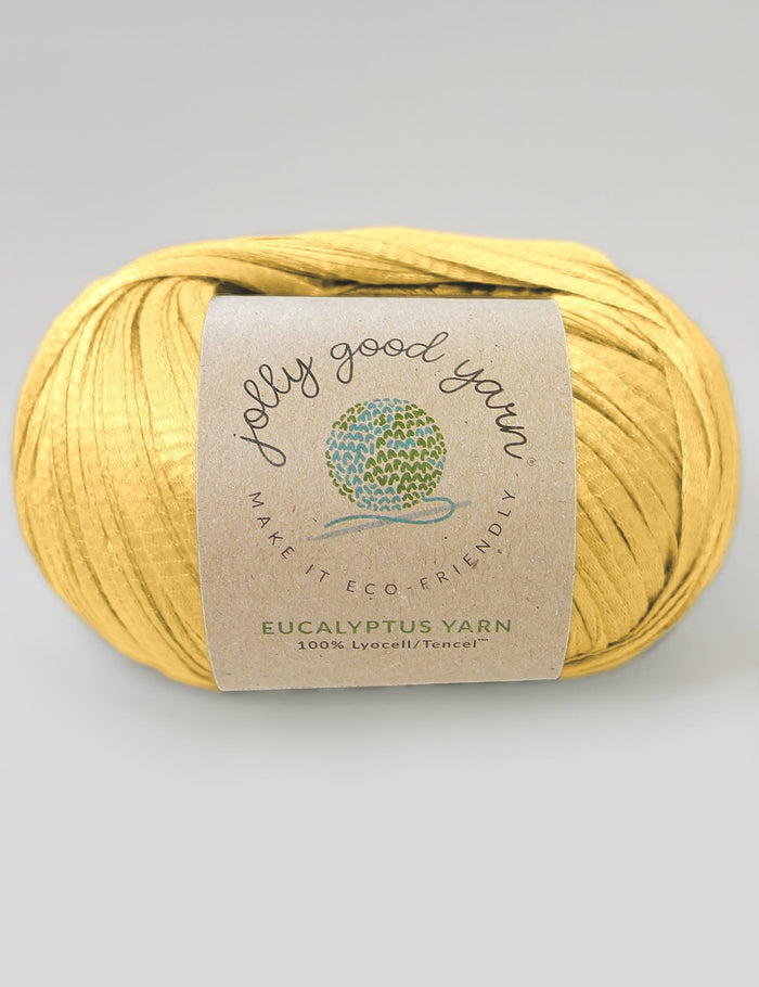 Yellow yarn ball with a label on a light gray background