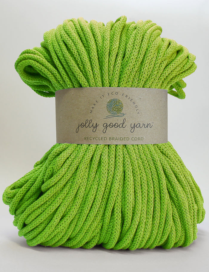 Green knitting cord made from recycled materials with a white background