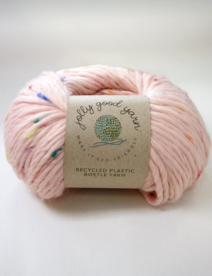 Pink yarn with colorful speckles and a label on a white background