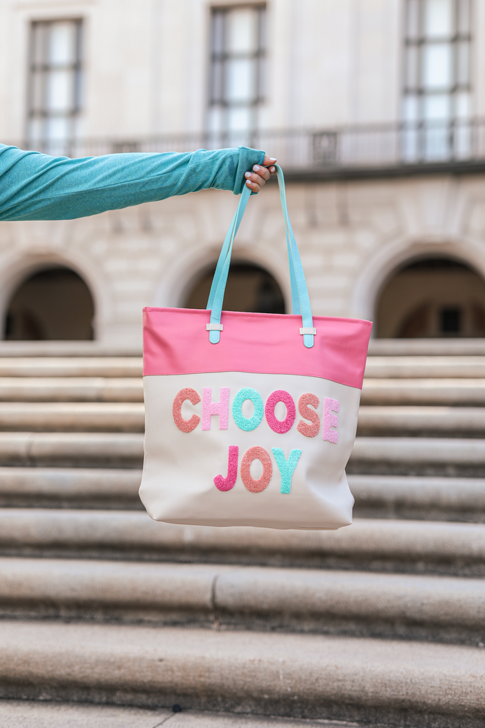 Colorful tote bag with 'CHOOSE JOY' design, featuring pink and cream colors, ideal for daily use.
