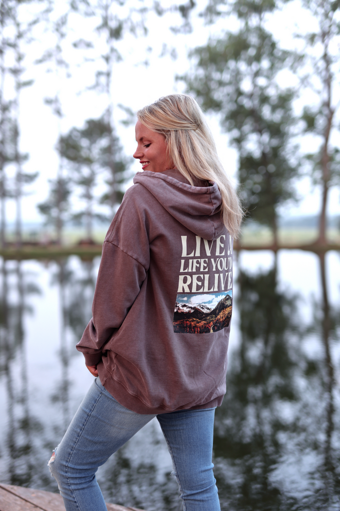 Brown oversized hoodie with mountain graphic, featuring 'LIVE A LIFE YOU'D RELIVE' text.