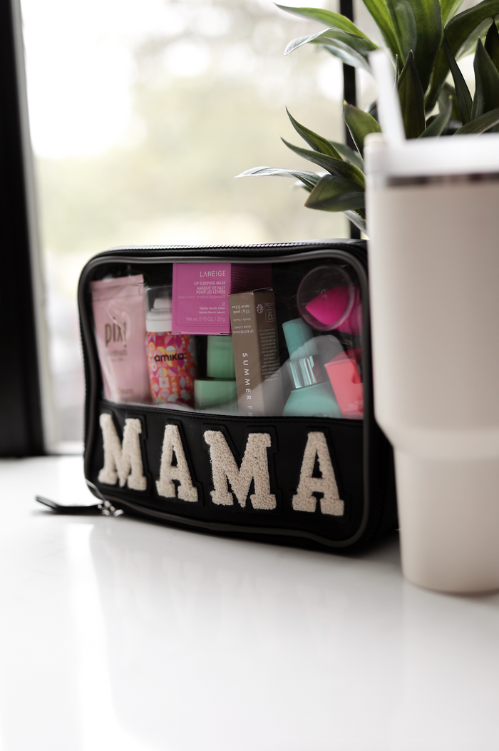 Black cosmetic bag with 'MAMA' design, filled with skincare and beauty products.