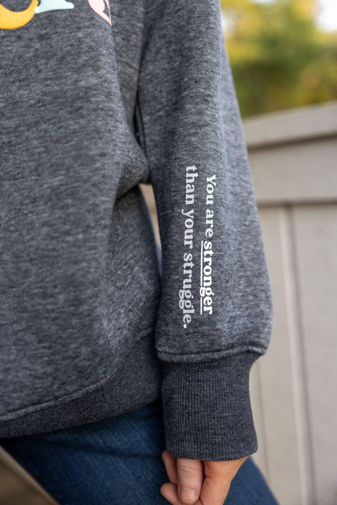 Grey sweatshirt featuring inspirational text on sleeve and soft, comfortable fabric for cozy wear.