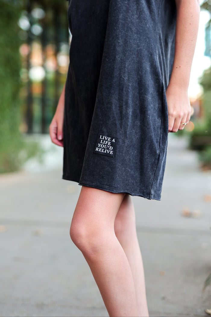 Black cotton dress with 'LIVE A LIFE YOU'D RELIVE' embroidered patch, perfect for casual outings.