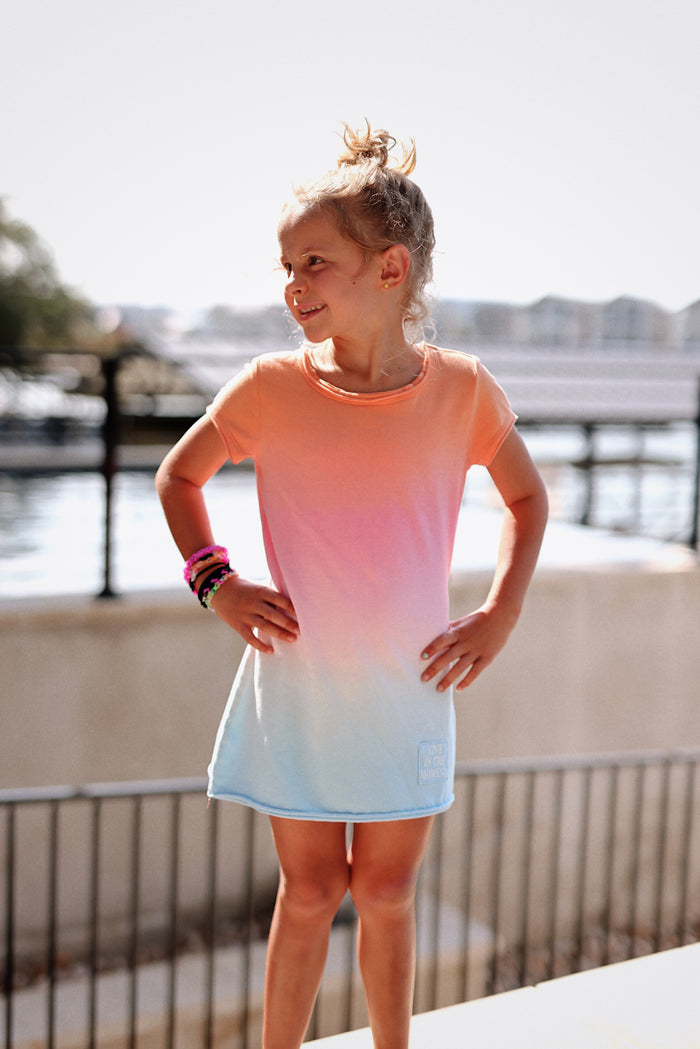 Girls' ombre t-shirt dress in peach and light blue, soft cotton fabric, featuring short sleeves and playful design.