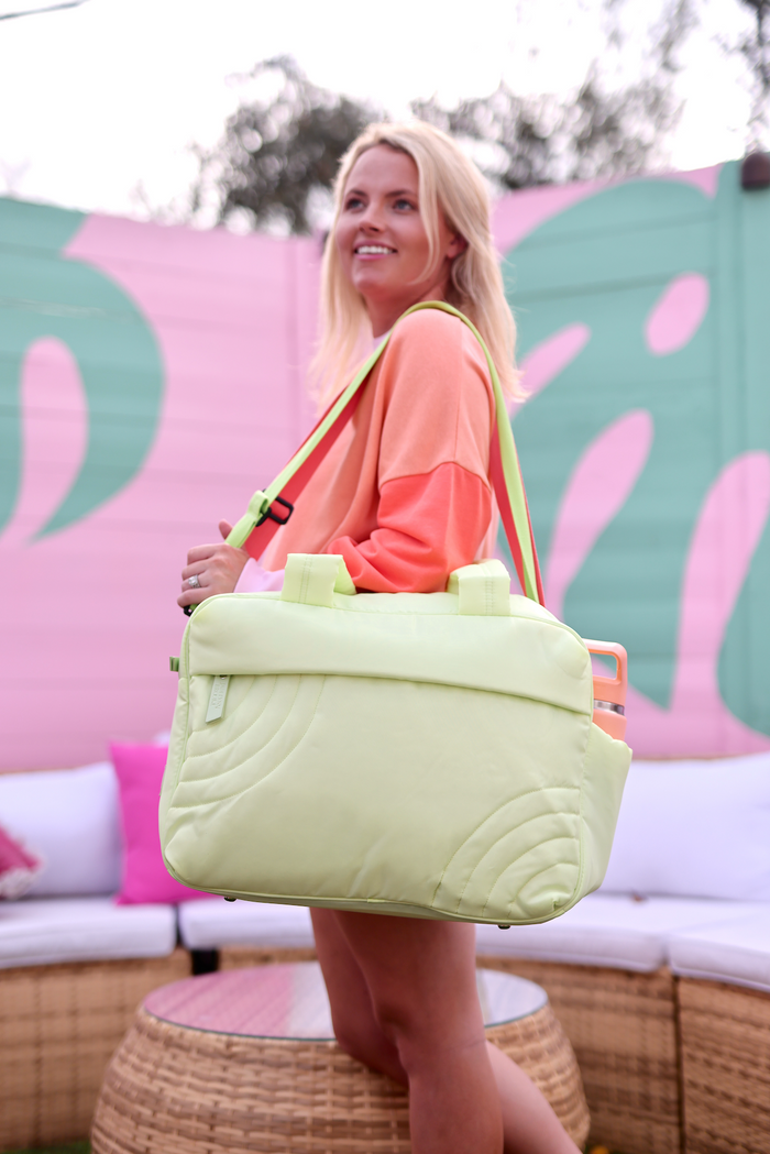 Stylish lime green travel bag with padded design and adjustable shoulder strap, perfect for on-the-go adventures.