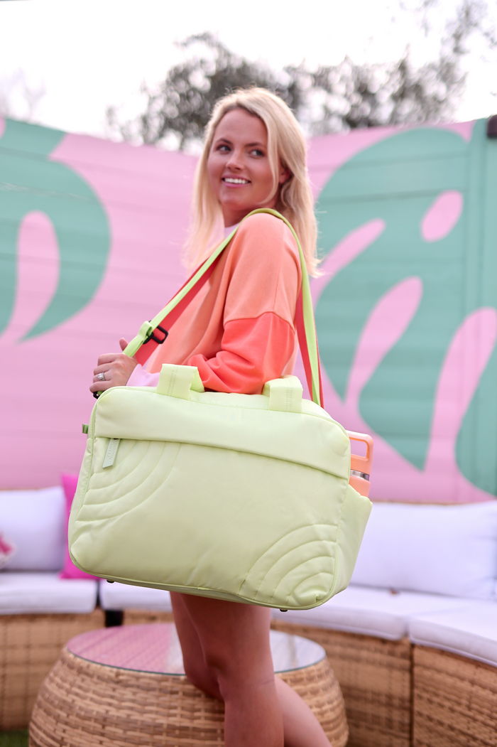 Light green stylish tote bag with adjustable shoulder strap, perfect for travel and everyday use.