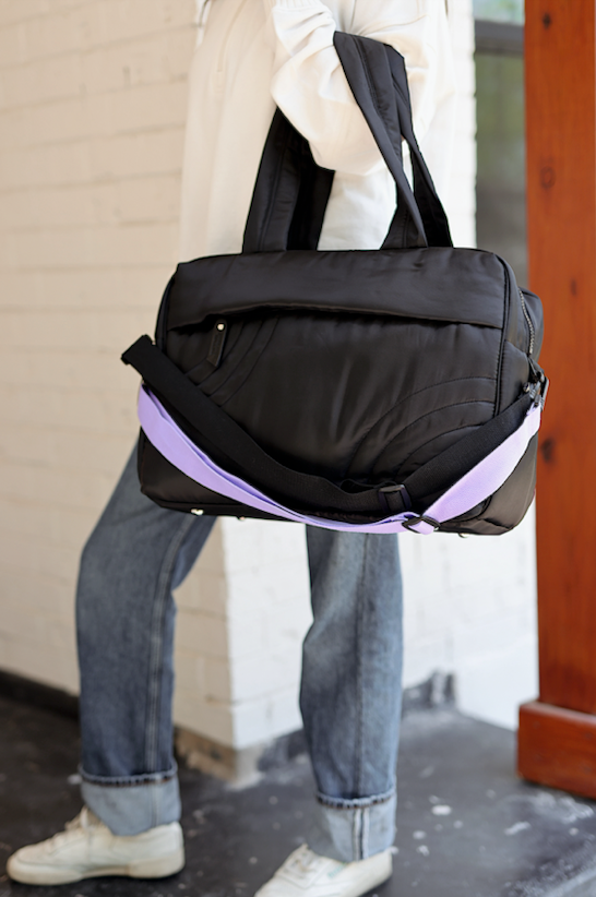 Stylish black nylon tote bag with detachable lavender strap, perfect for daily use and travel.