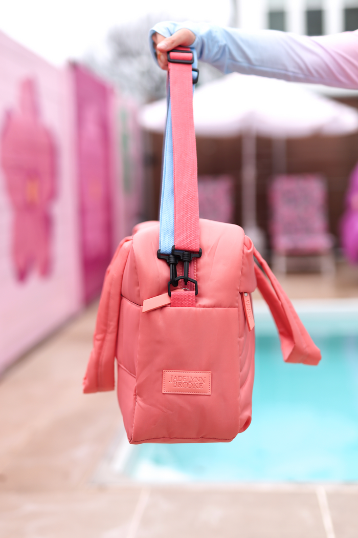 Coral pink insulated tote bag with adjustable blue strap, perfect for beach or picnic outings.