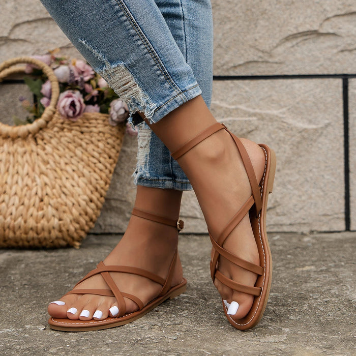 Criss-cross flat sandals worn on foot, casual styling