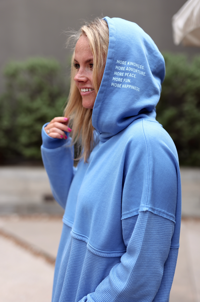 Light blue hoodie with inspirational text, made from soft material and featuring a cozy design.