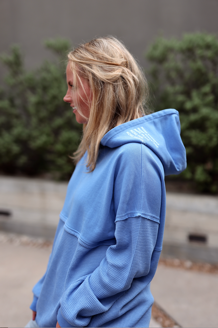 Light blue women's hoodie made from soft cotton, featuring a textured fabric and adjustable hood.