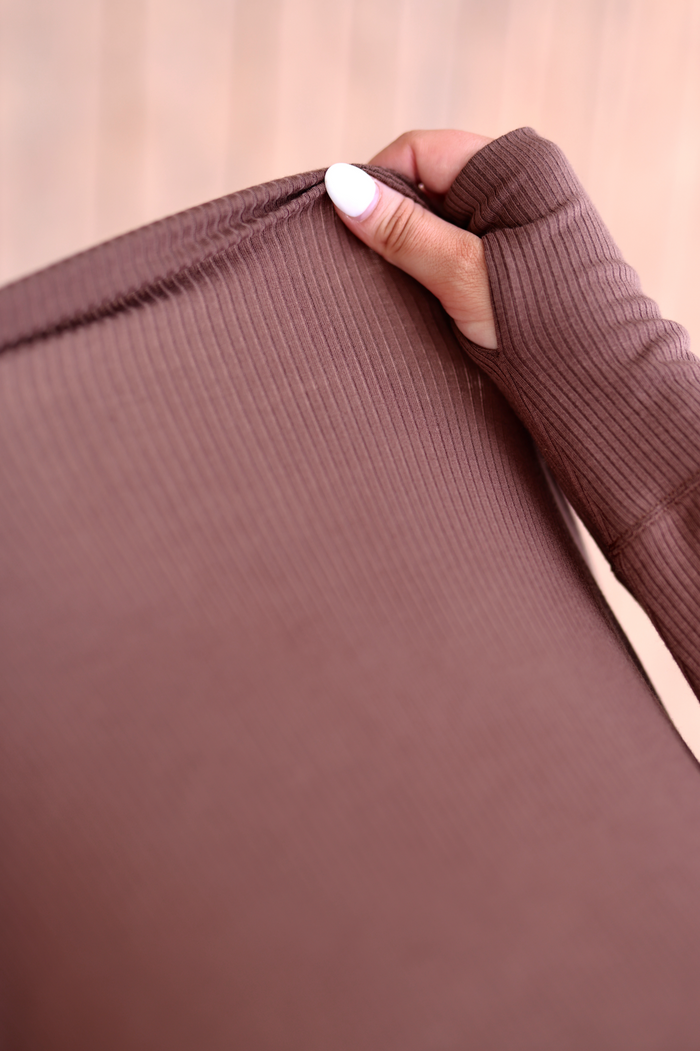 Close-up of a brown ribbed long sleeve top with thumbholes, perfect for layering or active wear.
