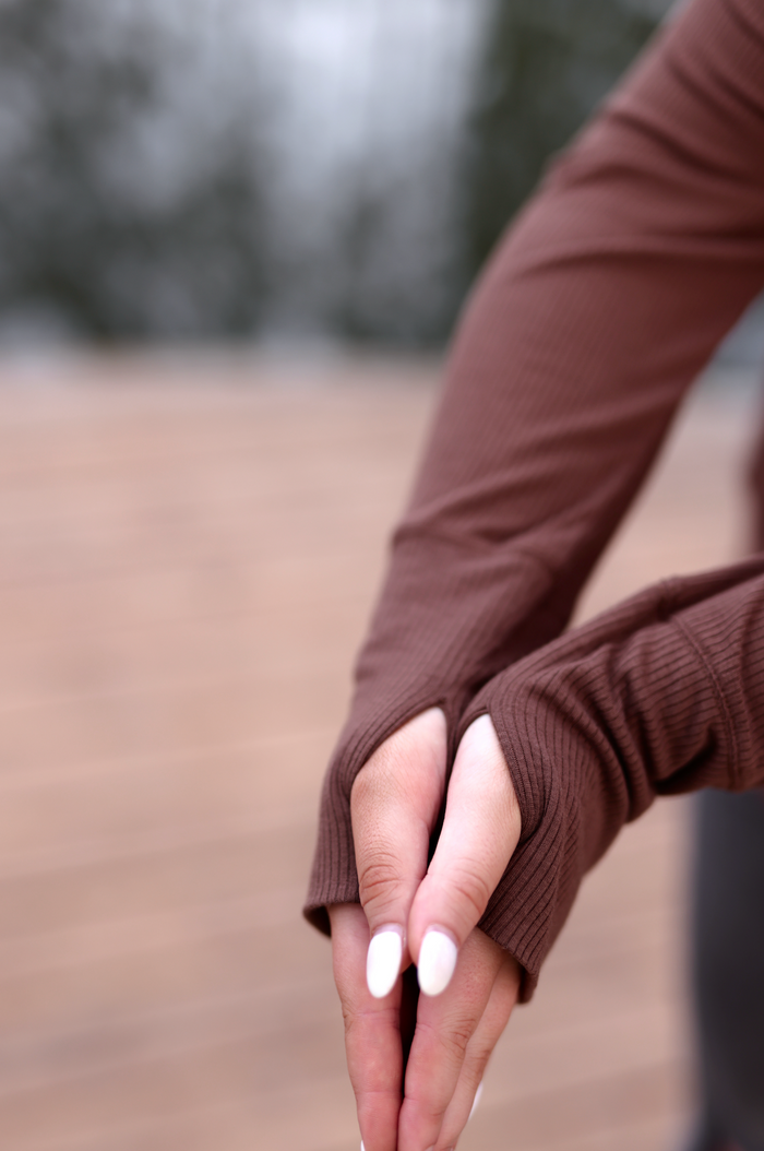 Brown ribbed long-sleeve top with thumbholes, ideal for casual and active wear.