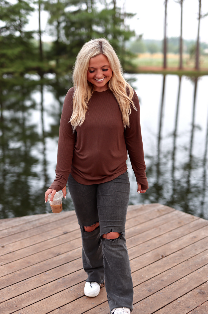 Casual outfit featuring a brown long-sleeve top and distressed gray jeans, perfect for relaxed outings.