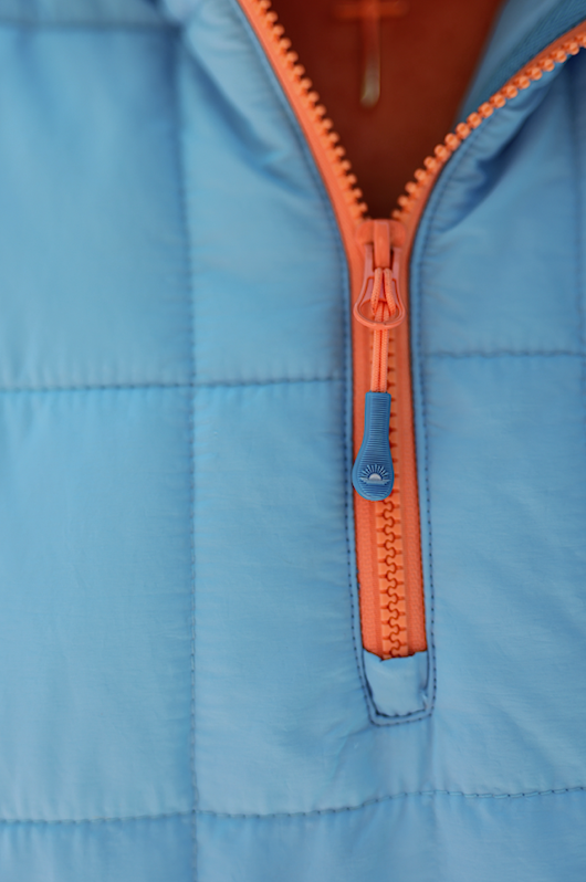 Light blue puffer jacket with orange zipper, ideal for warmth and style in cool weather.
