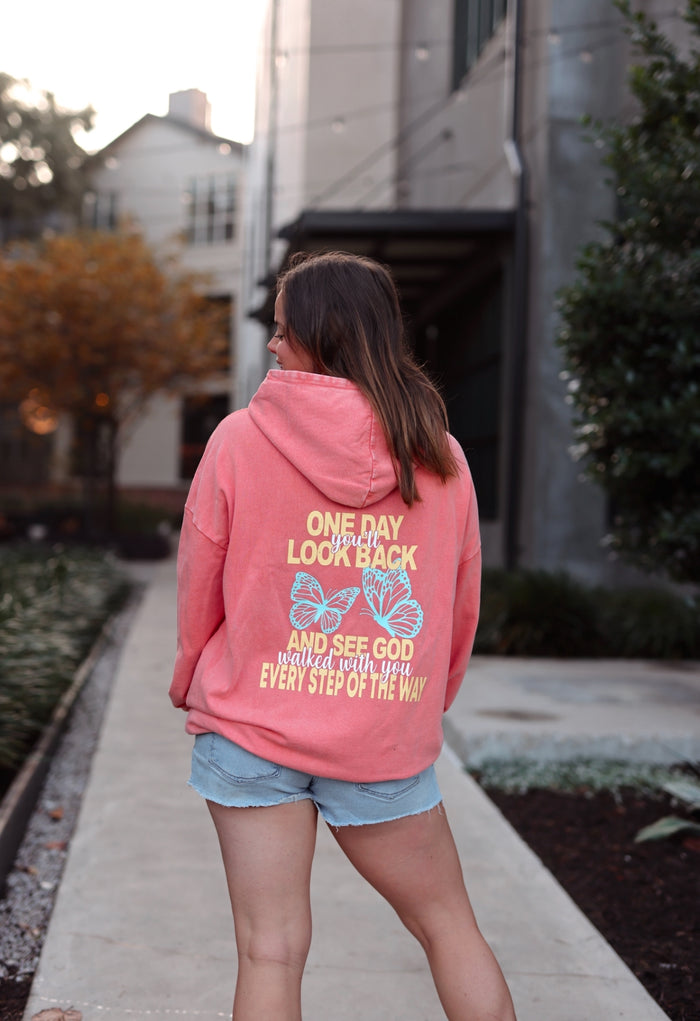 Pink hooded sweatshirt with inspirational butterfly print on back, perfect for casual wear.