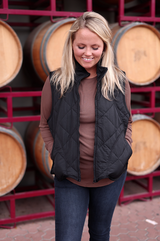 Women's black quilted vest, lightweight, perfect for layering over casual outfits.