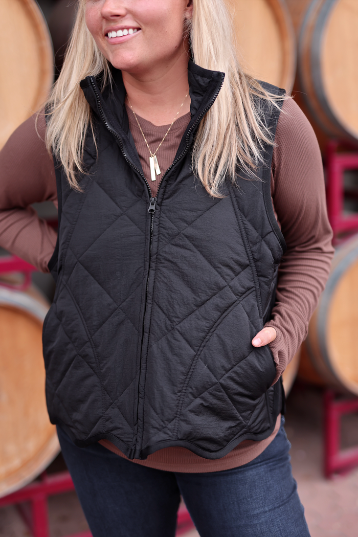 Women's black quilted vest made from lightweight material, perfect for layering in cool weather.